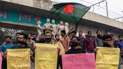 Students with black cloth tied over their faces hold placards during a silent protest to condemn the lynching of Hindu garment worker Dipu Chandra Das near the Raju Memorial Sculpture at Dhaka University in Dhaka on December 21. (AFP) Students with black cloth tied over their faces hold placards during a silent protest to condemn the lynching of Hindu garment worker Dipu Chandra Das near the Raju Memorial Sculpture at Dhaka University in Dhaka on December 21. (AFP)