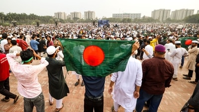 A mourner holds Bangladesh's national flag during the funeral of student leader Sharif Osman Hadi in Dhaka on December 20, after two days of violent protests over his killing (AFP) A mourner holds Bangladesh's national flag during the funeral of student leader Sharif Osman Hadi in Dhaka on December 20, after two days of violent protests over his killing (AFP)