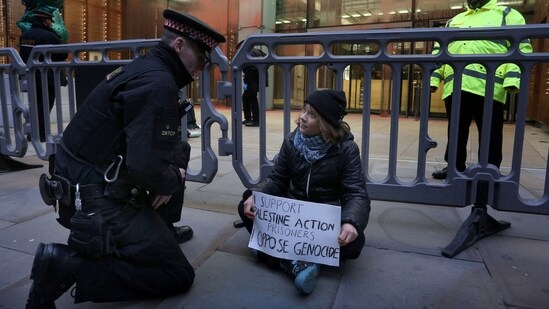 Swedish activist Greta Thunberg speaks to a police officer during a pro-Palestinian protest as she holds a sign that says she supports prisoners linked to Palestine Action, an organisation which the British government has proscribed as a terrorist group, in London, Britain, December 23, 2025.&nbsp;(via REUTERS)