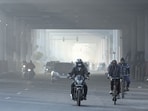People seen out on a cold and foggy morning at Indraprastha Extension Road in New Delhi.