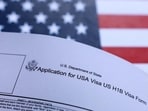 A US flag and US H-1B visa application form are seen in this illustration taken on September 26, 2025. A US flag and US H-1B visa application form are seen in this illustration taken on September 26, 2025.