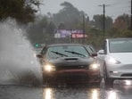 A car drives through a flooded road on La Cienega Boulevard on December 24, 2025 in Los Angeles, California. 