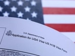 A US flag and US H-1B visa application form are seen in this illustration taken A US flag and US H-1B visa application form are seen in this illustration taken