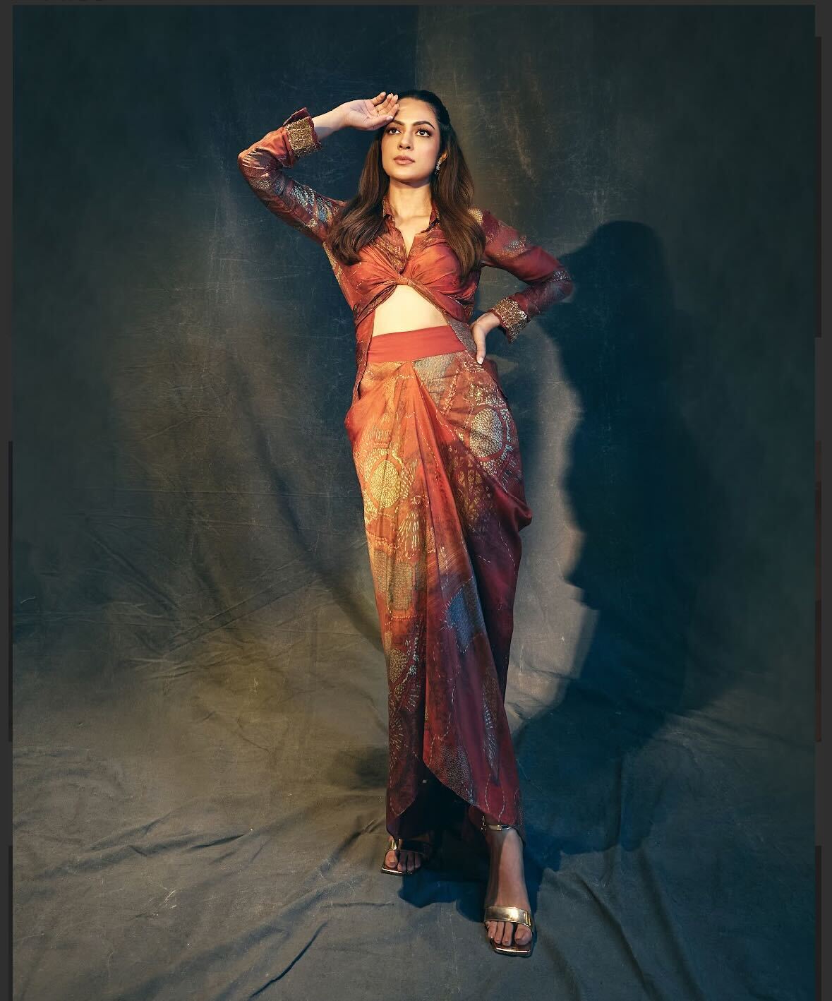 Outfit: Ose By Jyoti Gupta. Jewellery: RK Jewellers. Anyaa raises her style statement in a sculpted drape set from Ose By Jyoti Gupta, crafted in a rich rust-red palette with gold motifs. Her jewellery from RK Jewellers adds a subtle glow while metallic heels from A&S finish the look. Outfit: Ose By Jyoti Gupta. Jewellery: RK Jewellers. Anyaa raises her style statement in a sculpted drape set from Ose By Jyoti Gupta, crafted in a rich rust-red palette with gold motifs. Her jewellery from RK Jewellers adds a subtle glow while metallic heels from A&S finish the look.