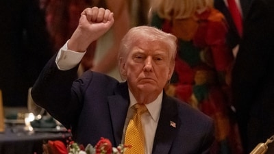 President Donald Trump pumps his fist at Christmas Eve dinner at his Mar-a-Lago club, Wednesday. (AP) President Donald Trump pumps his fist at Christmas Eve dinner at his Mar-a-Lago club, Wednesday. (AP)