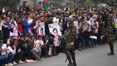 Law enforcement officers stand guard as supporters of Bangladesh Nationalist Party (BNP) acting chairman Tarique Rahman wait along the roadside to welcome their leader near the airport in Dhaka (AP) Law enforcement officers stand guard as supporters of Bangladesh Nationalist Party (BNP) acting chairman Tarique Rahman wait along the roadside to welcome their leader near the airport in Dhaka (AP)