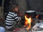 A child sits near a makeshift stove to stay warm on a winter morning in New Delhi.
