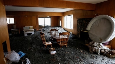 Chairs and a table stand partially buried inside a damaged house, as heavy rains fall due to an atmospheric river, in Wrightwood, California, U.S., December 26, 2025. (REUTERS)