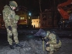 Police officers inspect the site of the Russian airstrike in Ukraine.