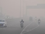 People commute amid dense smog and poor visibility in New Delhi on Sunday. (PTI)