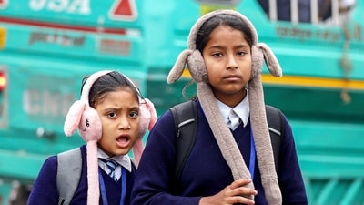 Girls clad in warm clothes on their way to school on a cold winter morning, in Lucknow on Tuesday. (Naeem Ansari)