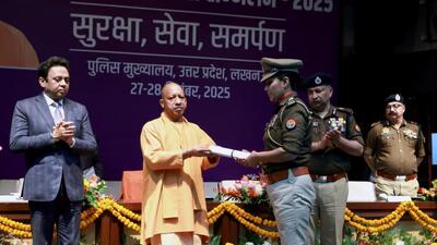 Chief minister Yogi Adityanath honouring a police officer at the Police Manthan in Lucknow. (HT)