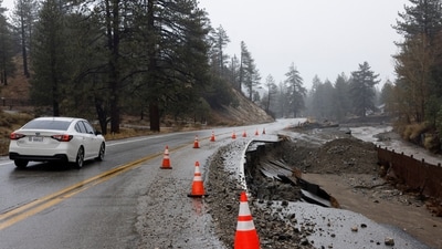 A car is driven next to traffic cones placed around a damaged portion of a road, as heavy rains fall due to an atmospheric river, in Wrightwood, California, U.S., December 26, 2025. REUTERS/Jill Connelly (REUTERS)