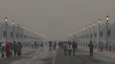 People walk at Kartavya Path as a layer of toxic smog engulfs the area, in New Delhi on Sunday. (Naveen Sharma/ANI) People walk at Kartavya Path as a layer of toxic smog engulfs the area, in New Delhi on Sunday. (Naveen Sharma/ANI)