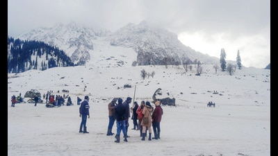 Tourists enjoy after a fresh spell of snowfall in Sonamarg on Monday. (ANI)