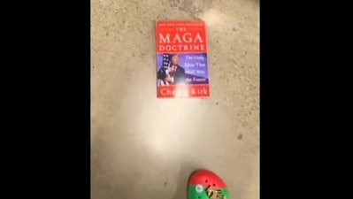 Woman grabs Charlie Kirk book & kicks it under US store shelf, viral video sparks backlash (X) Woman grabs Charlie Kirk book & kicks it under US store shelf, viral video sparks backlash (X)