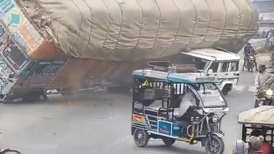 The truck toppled and crushed the Bolero car after it hit the road divider and lost balance. (HT Photos ) The truck toppled and crushed the Bolero car after it hit the road divider and lost balance. (HT Photos )