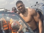 Former heavyweight boxing champion Anthony Joshua looks on as he gets into a vehicle following a car accident. 