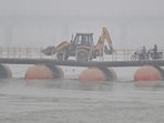 Commuters cross a pontoon bridge on a chilly and foggy day in Prayagraj on Tuesday (HT Photo)