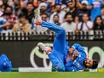 Shreyas Iyer reacts after sustaining an injury while taking the catch of Australia's Alex Carey.