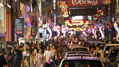Shoppers walk along Commercial Street illuminated with decorative lights ahead of New Year celebrations in Bengaluru on December 30, 2025. (AFP)