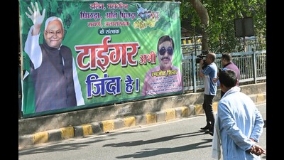 JD(U) supporters put posters outside the JD(U) office in Patna on the eve of vote counting for Bihar Assembly Elections 2025 on November 13. (Santosh Kumar/HT)