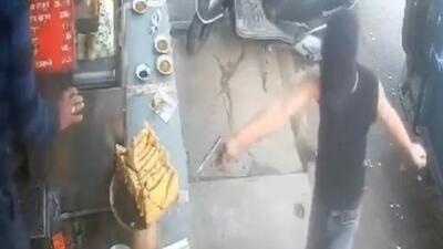 The screengrab of a CCTV footage showing one of the suspects with a gun threatening a shop owner.