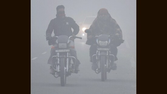 Bikers make their way amid dense fog on Friday morning. (Manish/HT)