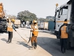 At the Metro 2B site, where ready mix concrete plants are operational, workers were seen sweeping the road At the Metro 2B site, where ready mix concrete plants are operational, workers were seen sweeping the road