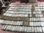 ED officials display cash seized during a search operation in New Delhi on Wednesday. (PTI)