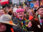 A person wearing 2026 glasses watches as organizers of the upcoming ball drop on New Year's Eve perform a confetti test in Times Square, New York, U.S., December 29, 2025. REUTERS/Adam Gray