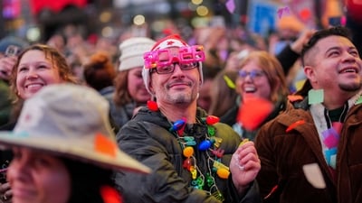 A person wearing 2026 glasses watches as organizers of the upcoming ball drop on New Year's Eve perform a confetti test in Times Square, New York, U.S., December 29, 2025. REUTERS/Adam Gray (REUTERS)