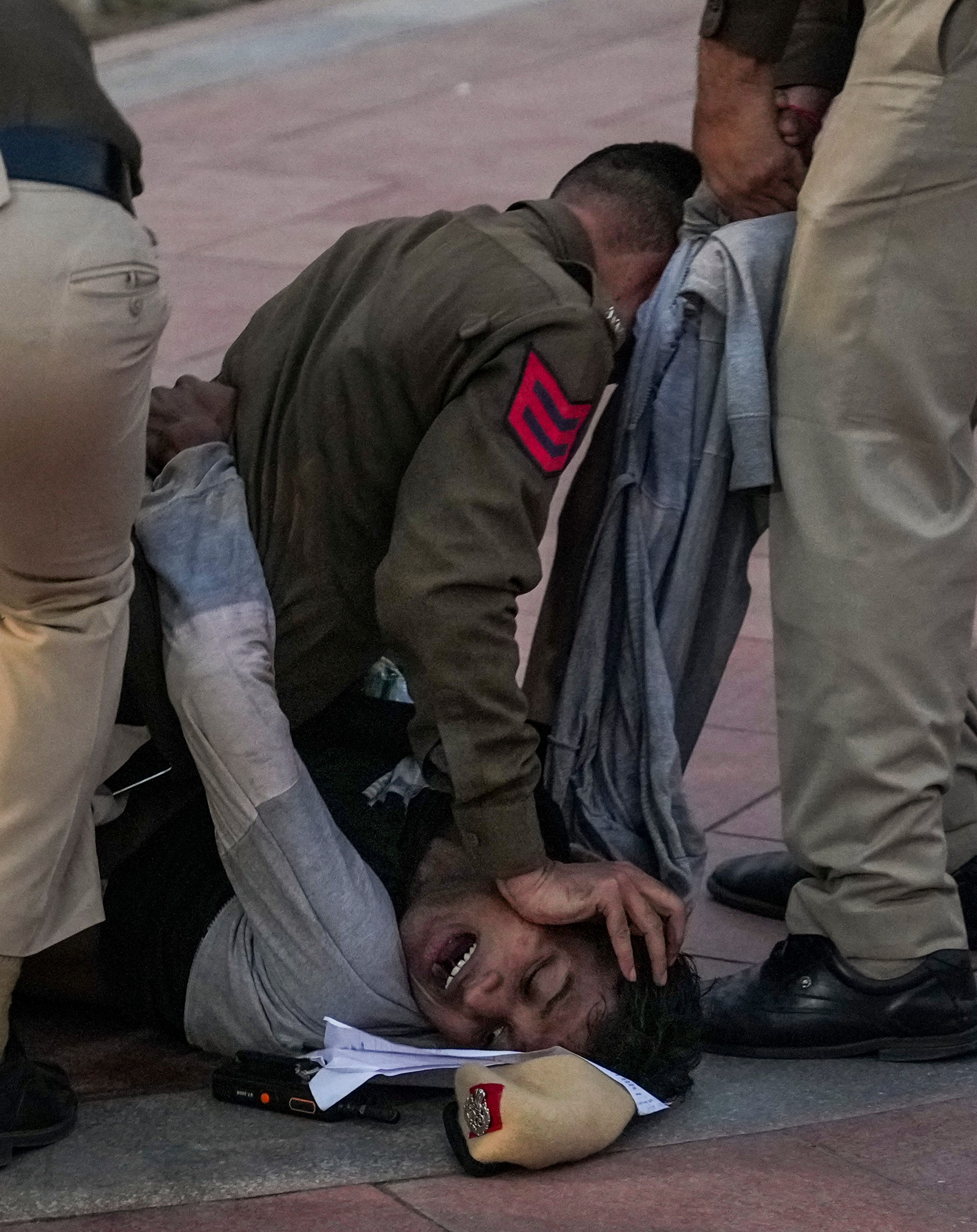 Police personnel detain a protester demonstrating against worsening air quality in the national capital near on November 23, 2025. (File Photo/PTI)
