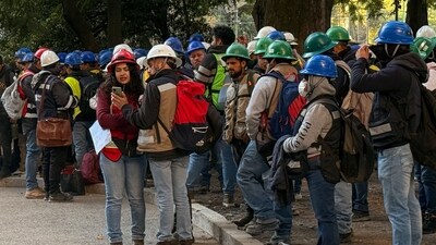 Workers of a construction site use their mobile phones on the street after they evacuated the site during a 6.5 magnitude earthquake in Mexico City. (AFP) Workers of a construction site use their mobile phones on the street after they evacuated the site during a 6.5 magnitude earthquake in Mexico City. (AFP)