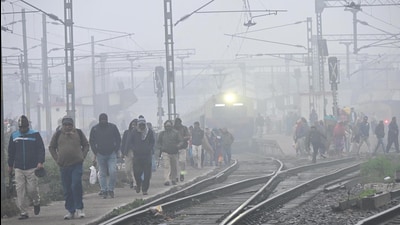 Passengers cross railway tracks amid dense fog at Patna Junction on Saturday. (Santosh Kumar/HT) Passengers cross railway tracks amid dense fog at Patna Junction on Saturday. (Santosh Kumar/HT)