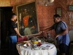 Jesus Linares, right, removes a painting of independence hero Simon Bolivar at his home, which he says was hit during U.S. military operations to capture Venezuelan President Nicolas Maduro, in Catia La Mar, Venezuela, Sunday, Jan. 4, 2026.