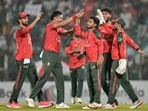 Taskin Ahmed celebrates with teammates after taking the wicket of Sherfane Rutherford.