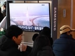 People sit in front of a television screen showing a news broadcast with file footage of a North Korean missile test, at a train station in Seoul on Sunday