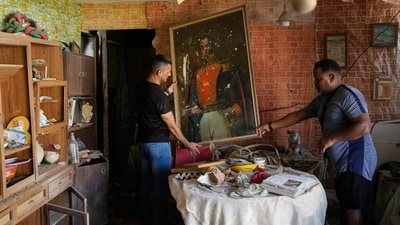 Jesus Linares, right, removes a painting of independence hero Simon Bolivar at his home, which he says was hit during U.S. military operations to capture Venezuelan President Nicolas Maduro, in Catia La Mar, Venezuela, Sunday, Jan. 4, 2026. (AP) Jesus Linares, right, removes a painting of independence hero Simon Bolivar at his home, which he says was hit during U.S. military operations to capture Venezuelan President Nicolas Maduro, in Catia La Mar, Venezuela, Sunday, Jan. 4, 2026. (AP)