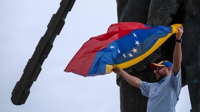 A Venezuelan living in Mexico waves a national flag as he celebrates at the Cuauhtemoc monument in Tijuana, Mexico, on January 3, 2026, after US forces captured Venezuelan leader Nicolas Maduro. (Photo by Guillermo Arias / AFP) (AFP) A Venezuelan living in Mexico waves a national flag as he celebrates at the Cuauhtemoc monument in Tijuana, Mexico, on January 3, 2026, after US forces captured Venezuelan leader Nicolas Maduro. (Photo by Guillermo Arias / AFP) (AFP)