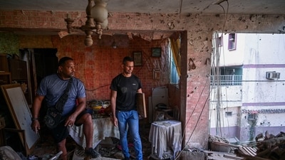 Jesus Linares and his work partner Reggie Carrera stand at his damaged apartment, after the US strike on Venezuela, capturing its President Nicolas Maduro and his wife Cilia Flores, in Catia La Mar, Venezuela, on January 4. (Gaby Oraa/Reuters Photo)