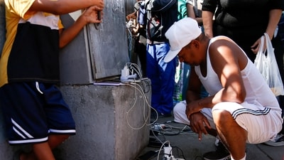 People charge their phones, as several neighborhoods remain without electricity after the U.S. launched a strike on Venezuela, capturing its President Nicolas Maduro and his wife Cilia Flores, in Caracas, Venezuela January 4, 2026. REUTERS/Leonardo Fernandez Viloria (REUTERS)