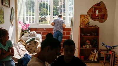 People sit inside a home where a wall was punctured by a rocket fragment, after the U.S. launched a strike on Venezuela, capturing its President Nicolas Maduro and his wife Cilia Flores, in Caracas, Venezuela January 4, 2026. REUTERS/Leonardo Fernandez Viloria (REUTERS)
