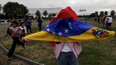 A woman holds a flag as Venezuelans living in Chile gather to celebrate, after the United States struck Venezuela and captured its President Nicolas Maduro and his wife Cilia Flores overnight, in Concepcion, Chile, January 3, 2026. (REUTERS/Juan Gonzalez) (REUTERS)
