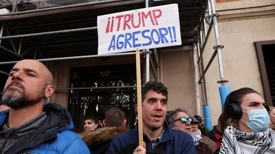 A man holds a placard reading "Trump the aggressor" as demonstrators protest outside the U.S. Embassy in Madrid against the U.S. strike on Venezuela, and capture of its President Nicolas Maduro and his wife Cilia Flores, in Madrid, Spain, January 4, 2026. REUTERS/Violeta Santos Moura (REUTERS)