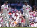 Australia's Travis Head, right, watches a third umpire video review. 