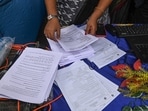 Election Commission officials assist voters at a help desk camp for the Special Intensive Revision (SIR) of electoral rolls