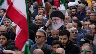 A demonstrator holds up a poster of the Iranian Supreme Leader Ayatollah Ali Khamenei next to the Iranian flags (AP/Representational)