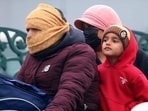 A family braving the winter chill at a traffic crossing in Bathinda on Wednesday. Residents were wrapped up in woollens to brave the biting cold. (Sanjeev Kumar/HT)