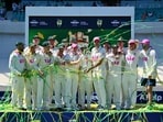 Australian players celebrate with the Waterford Crystal Ashes Trophy at the end of the fifth Ashes cricket Test between Australia and England at Sydney Cricket Ground on January 8, 2026. (Photo by Saeed KHAN / AFP) / -- IMAGE RESTRICTED TO EDITORIAL USE - STRICTLY NO COMMERCIAL USE --